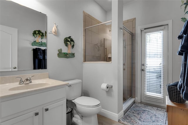 bathroom featuring vanity, toilet, and a shower with door