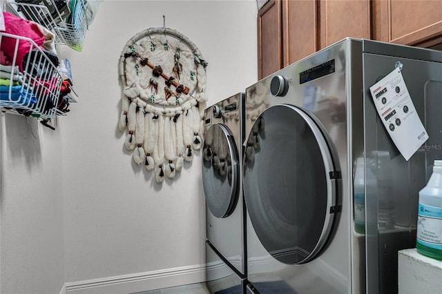 laundry area with washing machine and dryer and cabinets