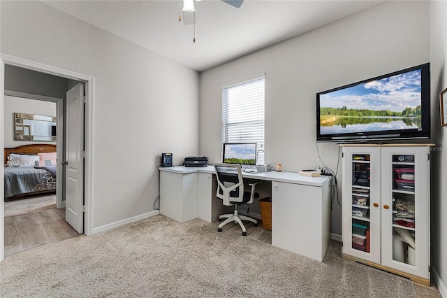 home office with baseboards, wine cooler, a ceiling fan, and light colored carpet