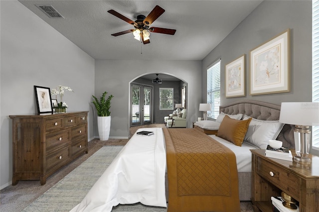 carpeted bedroom featuring visible vents, arched walkways, baseboards, and french doors