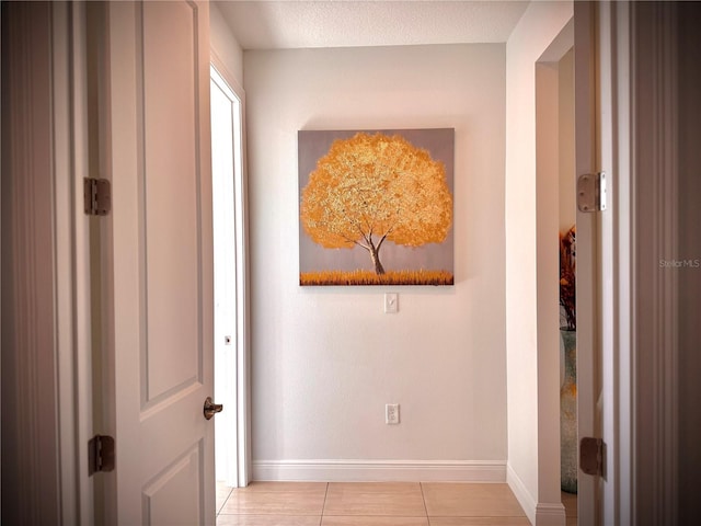 hall with light tile patterned floors and a textured ceiling