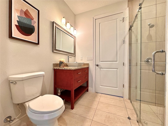 bathroom with a textured ceiling, tile patterned flooring, a shower with door, vanity, and toilet