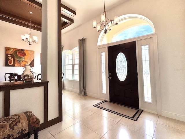 tiled foyer with beam ceiling and a chandelier