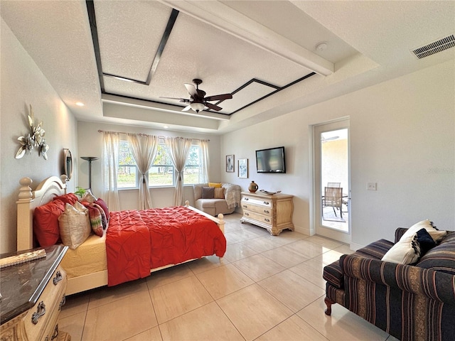 tiled bedroom with ceiling fan, access to exterior, and a raised ceiling