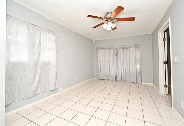 tiled empty room with ceiling fan and a textured ceiling