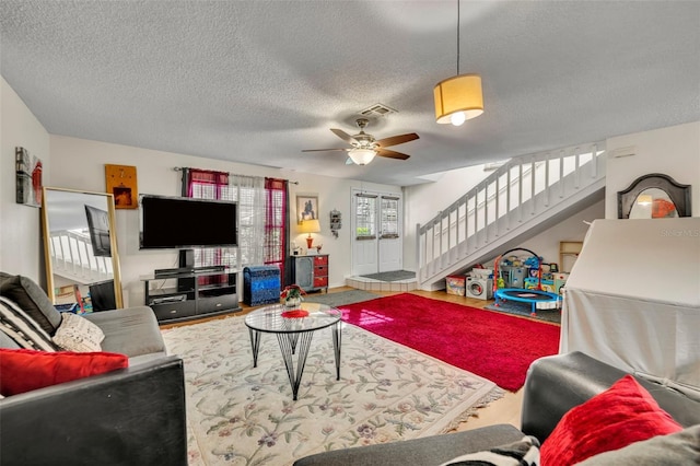 living room featuring a textured ceiling and ceiling fan