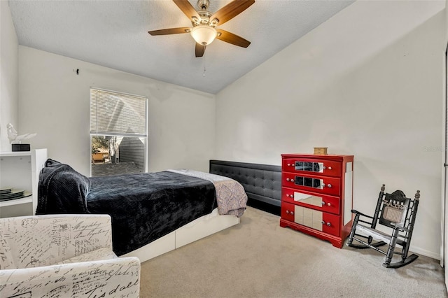 bedroom with carpet flooring, lofted ceiling, ceiling fan, and a textured ceiling