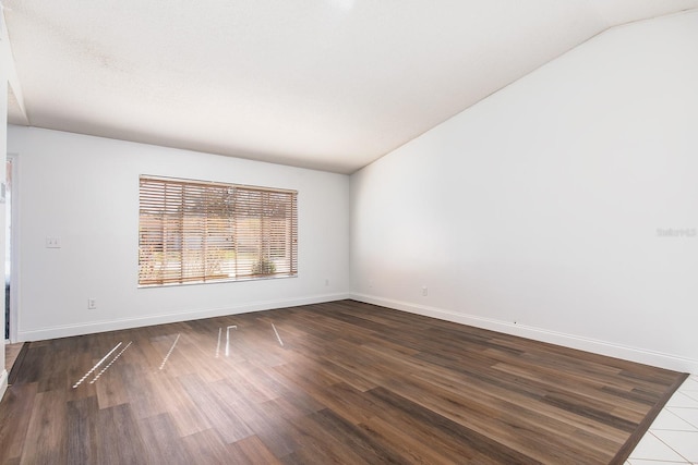 empty room featuring dark hardwood / wood-style flooring and vaulted ceiling