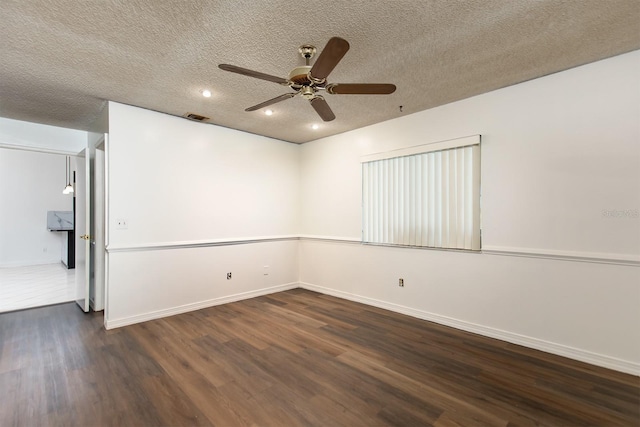 empty room with ceiling fan, dark hardwood / wood-style flooring, and a textured ceiling