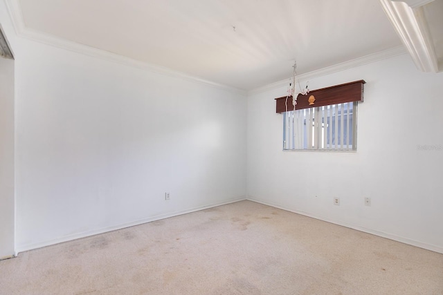 carpeted spare room featuring crown molding and a chandelier