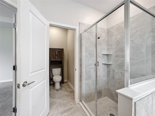 bathroom featuring toilet, tile patterned flooring, and a shower with door