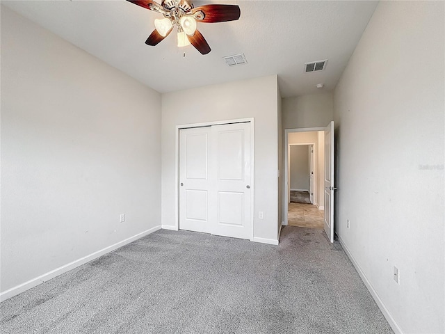 unfurnished bedroom with ceiling fan, a closet, and carpet floors