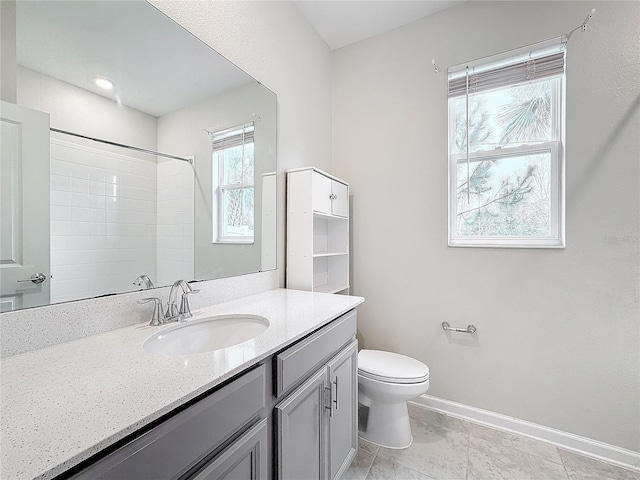 bathroom with toilet, vanity, and a shower