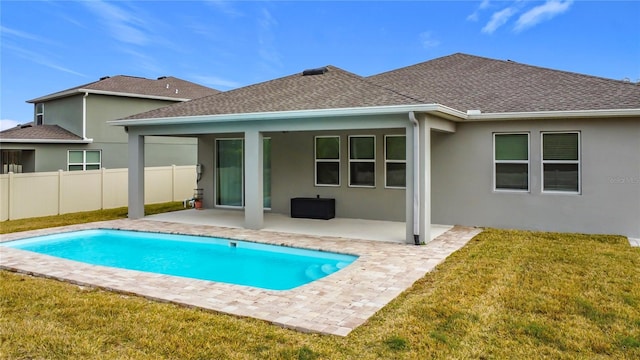 back of property featuring a patio area, a fenced in pool, and a lawn