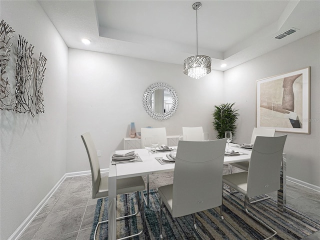 dining space with a raised ceiling