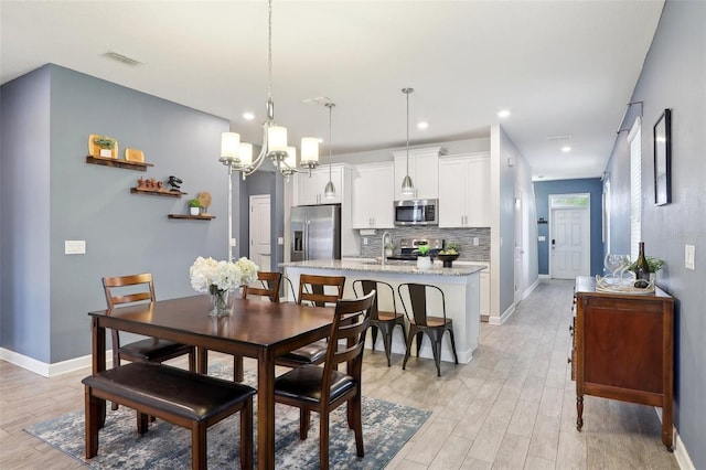 dining room with a notable chandelier and light hardwood / wood-style floors