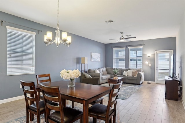 dining room with ceiling fan with notable chandelier