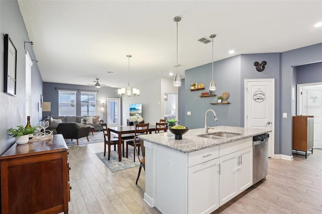 kitchen featuring sink, white cabinets, dishwasher, ceiling fan with notable chandelier, and a kitchen island with sink