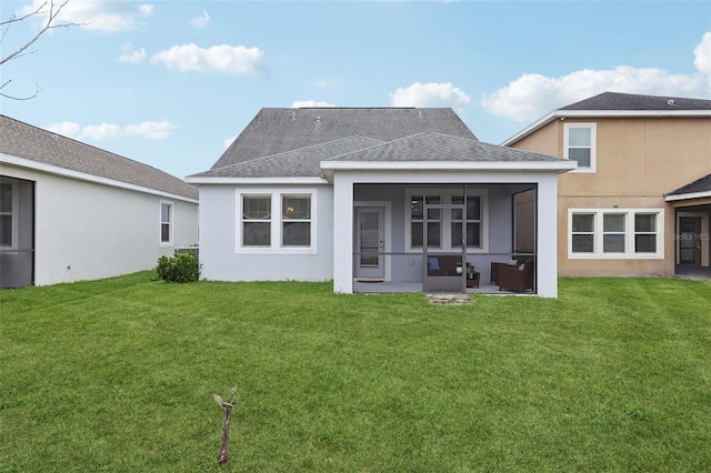 rear view of house with a lawn and a sunroom