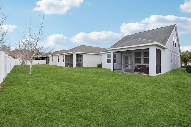 rear view of property featuring a sunroom and a lawn