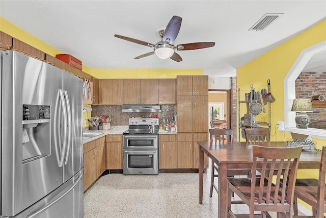 kitchen featuring range hood, ceiling fan, appliances with stainless steel finishes, and decorative backsplash