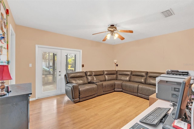 living room with light wood-type flooring, ceiling fan, and french doors