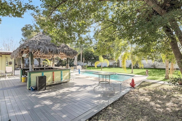 exterior space featuring a deck, a lawn, and exterior bar