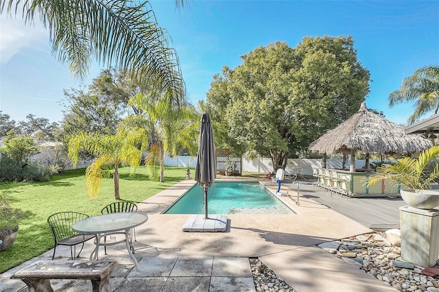 view of pool with a gazebo, a bar, a patio, and a yard