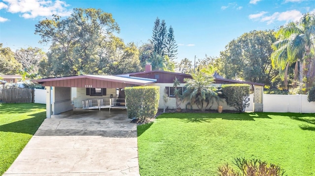 ranch-style home featuring a front lawn and a carport