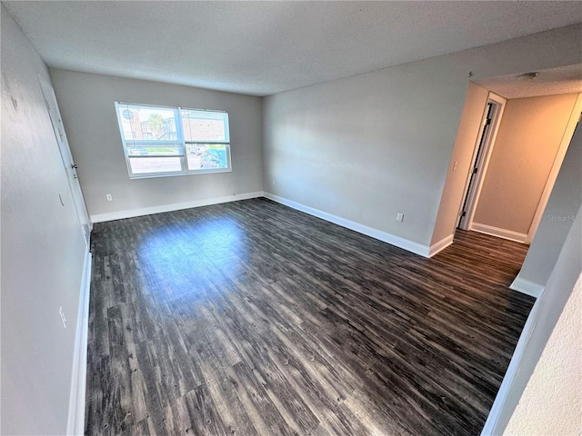 spare room with dark hardwood / wood-style flooring and a textured ceiling