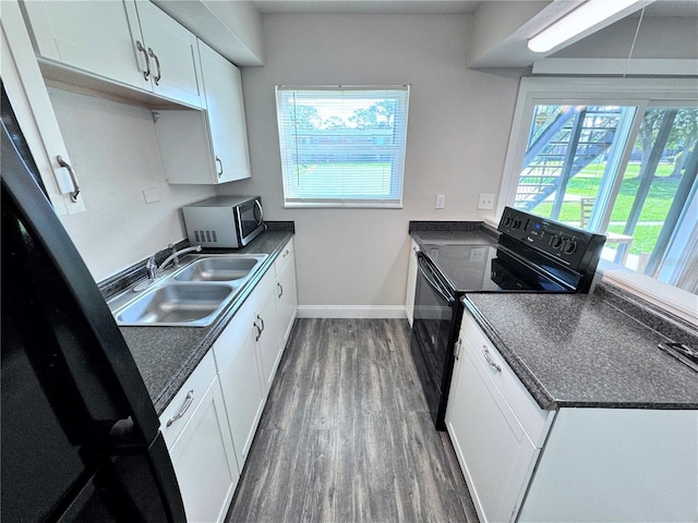 kitchen featuring black range with electric stovetop, sink, white cabinets, and dark hardwood / wood-style floors