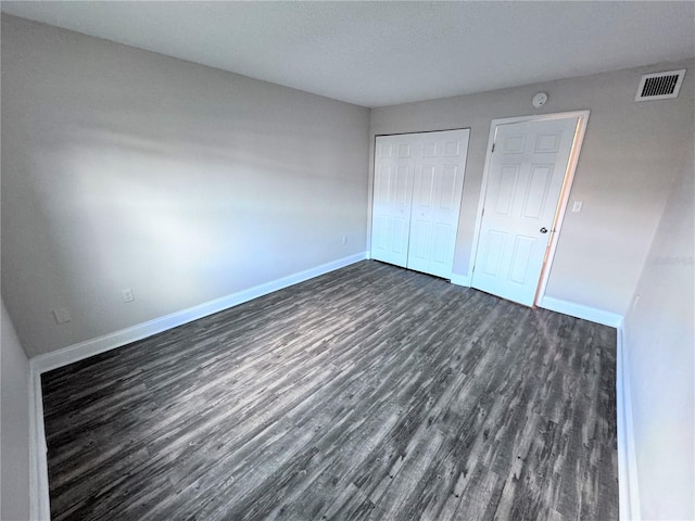 unfurnished bedroom with dark hardwood / wood-style floors