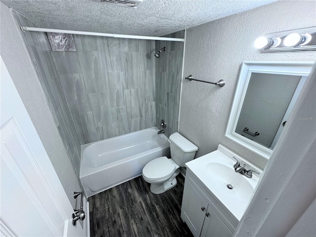 full bathroom featuring vanity, hardwood / wood-style flooring, toilet, a textured ceiling, and shower / bath combination