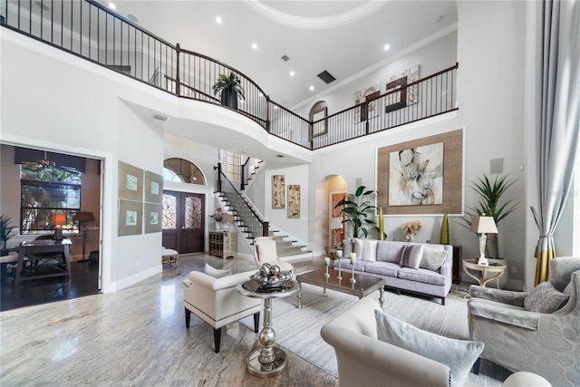 living room with crown molding, a high ceiling, and french doors