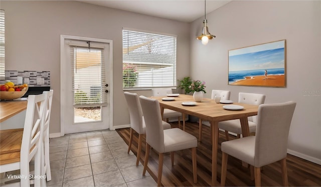 tiled dining area featuring vaulted ceiling