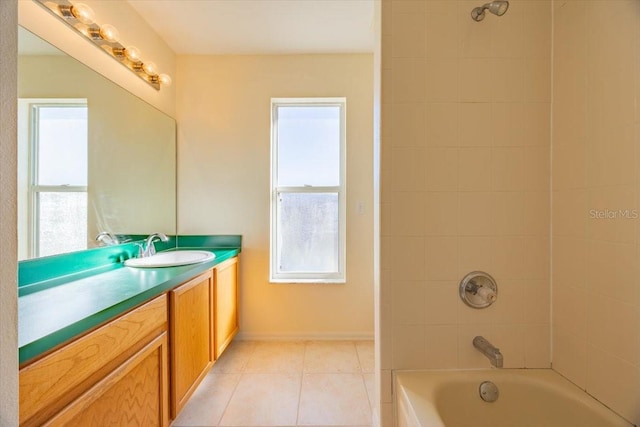 bathroom featuring tile patterned flooring, vanity, tiled shower / bath, and a healthy amount of sunlight