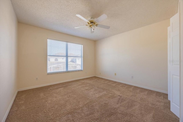 spare room with carpet flooring, ceiling fan, and a textured ceiling