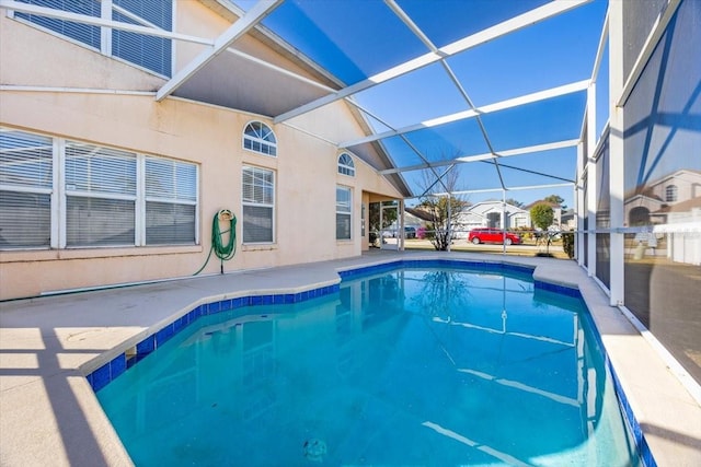 view of swimming pool with glass enclosure and a patio