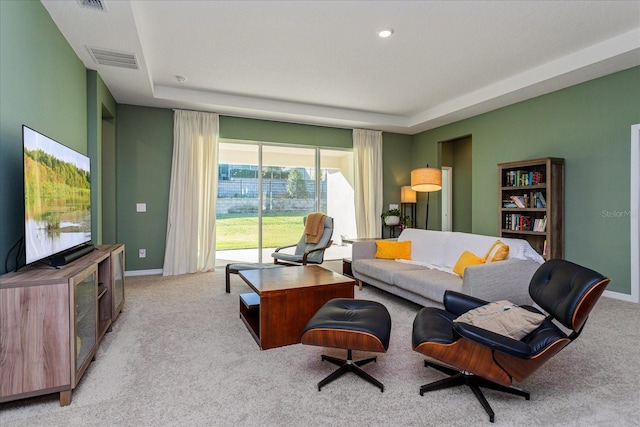 carpeted living room featuring a raised ceiling