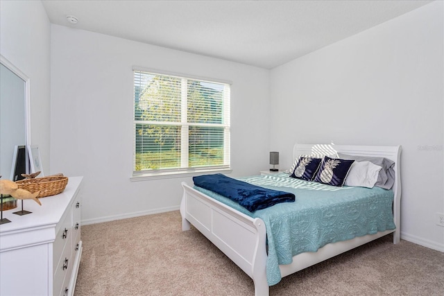 bedroom with multiple windows and light colored carpet