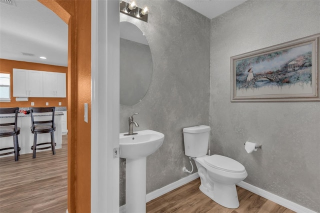 bathroom with sink, wood-type flooring, and toilet