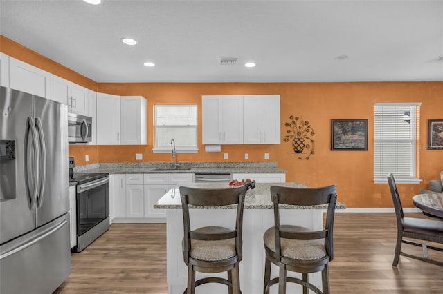 kitchen with light stone countertops, white cabinets, and appliances with stainless steel finishes