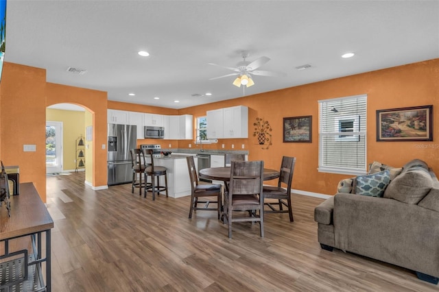 dining space with ceiling fan and light hardwood / wood-style flooring