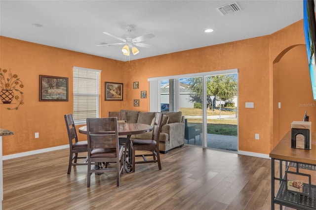 dining space with ceiling fan and wood-type flooring