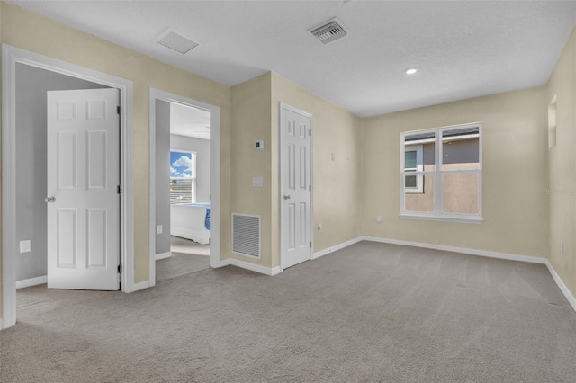 empty room featuring carpet and a textured ceiling