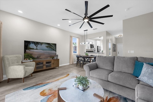 living room with ceiling fan and light wood-type flooring