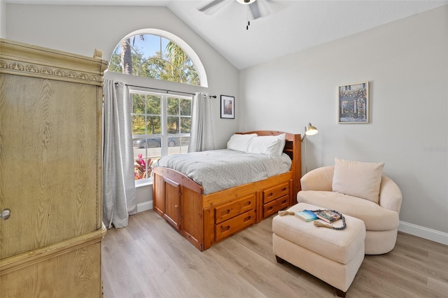 bedroom with ceiling fan, light hardwood / wood-style floors, and lofted ceiling