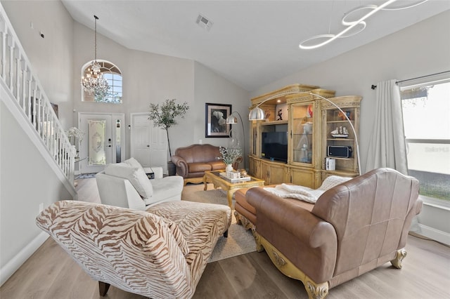 living room featuring light hardwood / wood-style floors, a wealth of natural light, and a notable chandelier