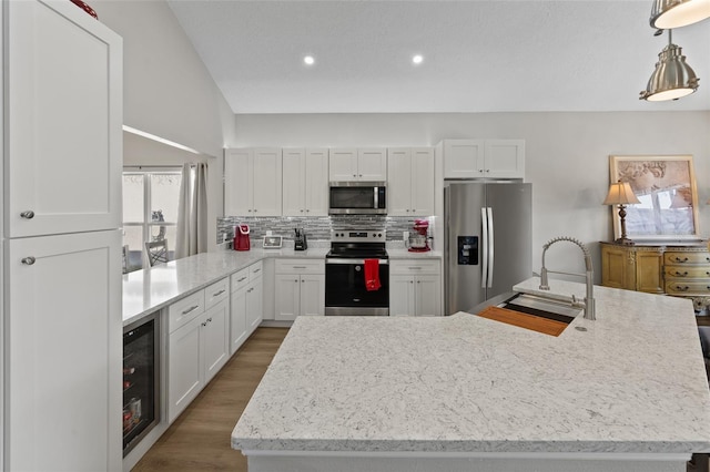 kitchen with sink, white cabinetry, stainless steel appliances, and wine cooler