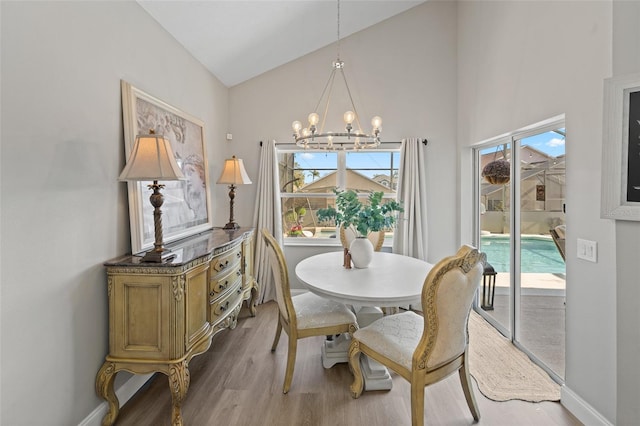 dining room featuring vaulted ceiling, light hardwood / wood-style flooring, and a notable chandelier